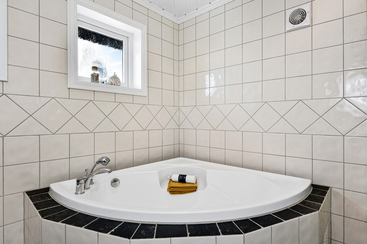 Badet er romslig og er innredet med et innfliset hjørnebadekar. Galleribilde