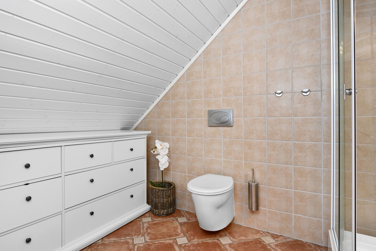 Badet er romslig og har et vegg montert toalett. Galleribilde