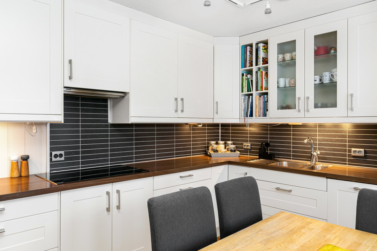 Gode oppbevaringsmuligheter i over- og underskap, samt god benkeplass. Backsplash mellom bankeplate og overskap.