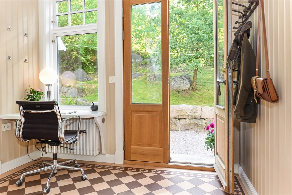Inngangsdører i eik og glass. Gulvet har gjennomfargede engelske fliser. Galleribilde