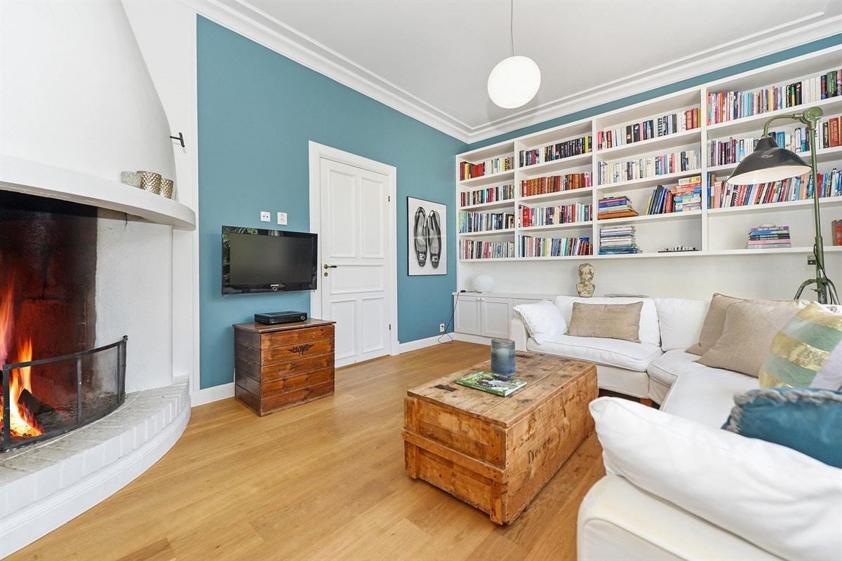 I tv-stuen er det plassbygde hyller og skap på en vegg. Galleribilde