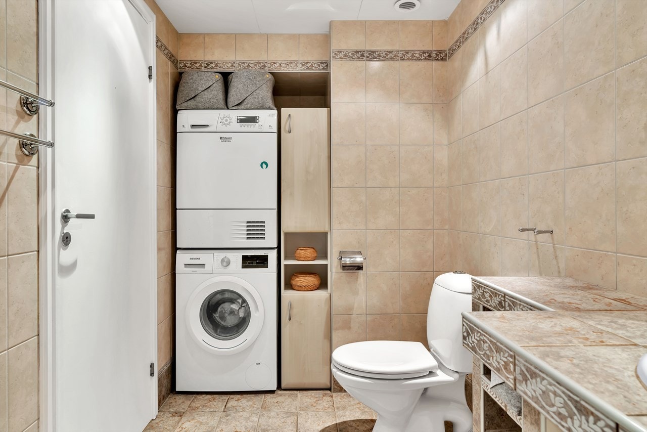 Badet har ellers praktisk nisje med vaskemaskin og tørketrommel, samt romslig dusjhjørne. Galleribilde