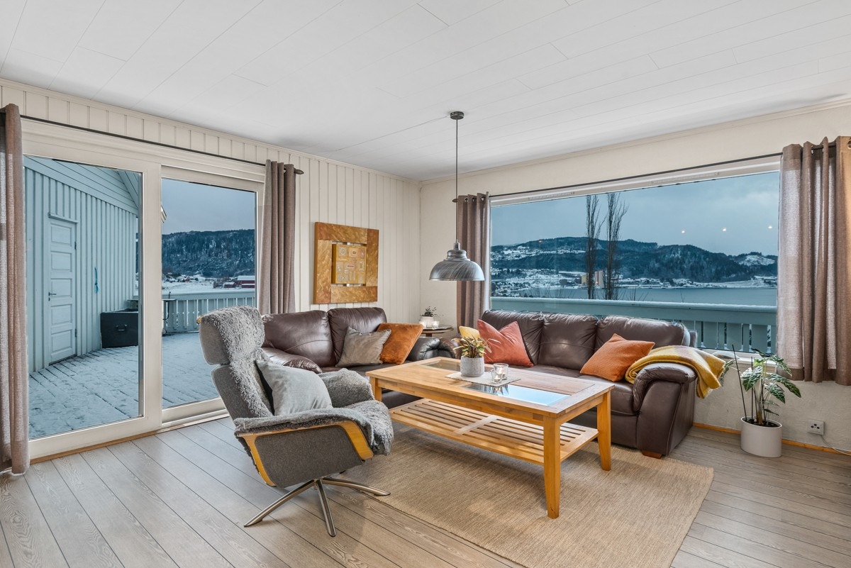 Stuevinduene er store og rammer inn den herlige utsikten, og det er skyvedører i glass til balkong. Galleribilde