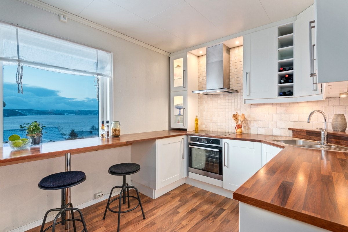 Kjøkkeninnredningen har pent, tidløst design og byr på god skap- og benkeplass. Det er enkelte hvitevarer integrert. Galleribilde