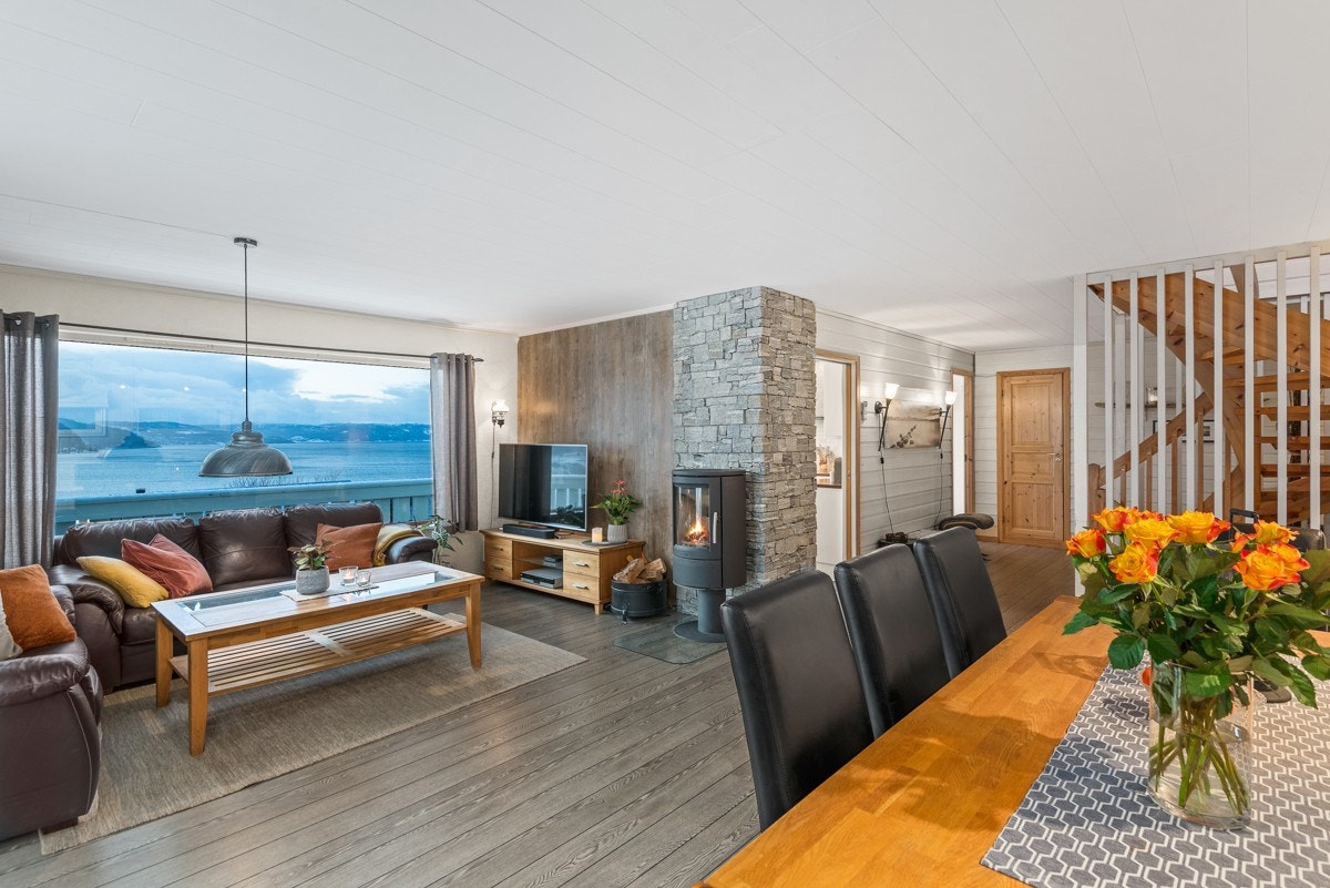 Stuen er lunt innredet med askegrått gulv, panel og naturstein. Galleribilde