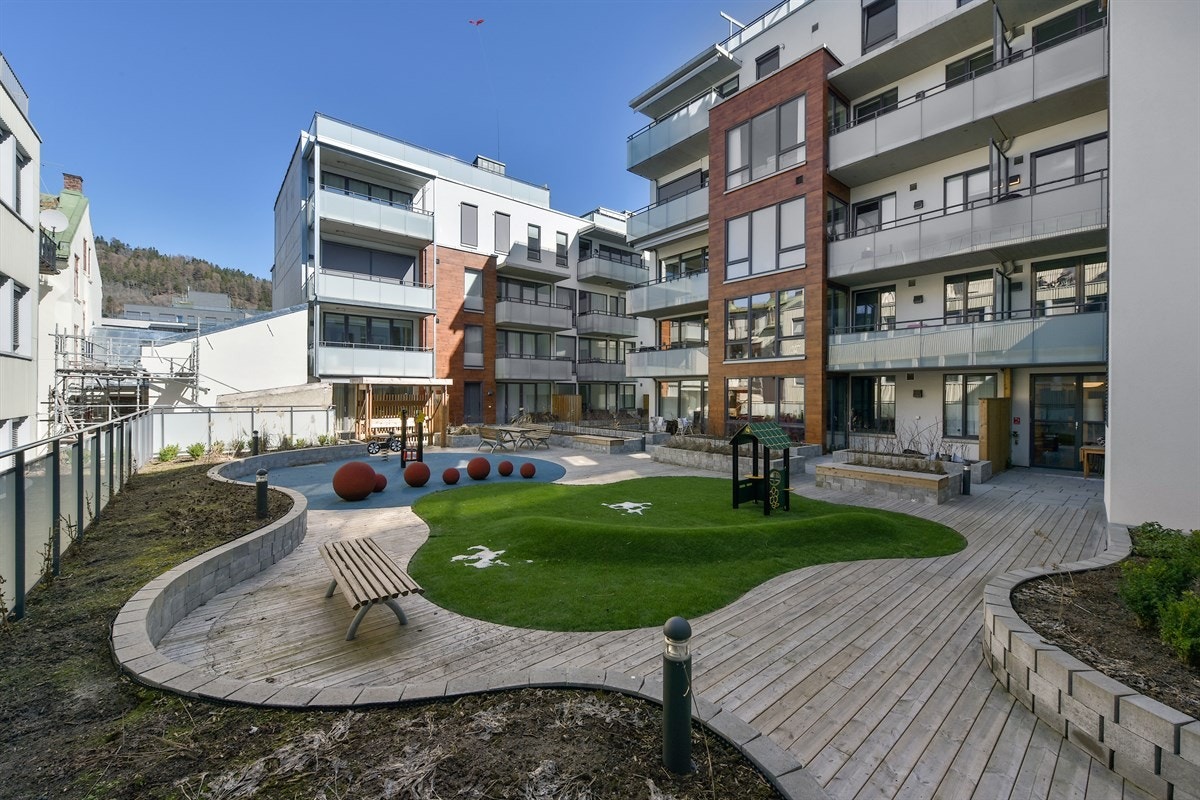 Felles stort skjermet grønt atrium nedenfor leiligheten. Galleribilde