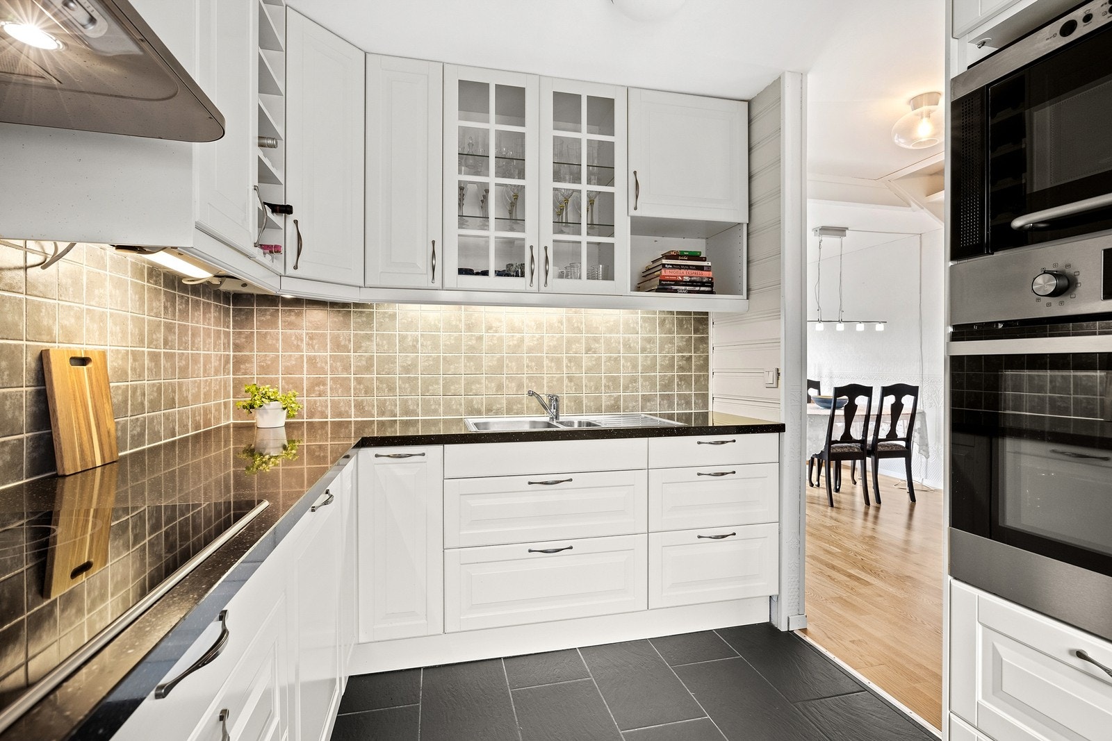 Pent kjøkken med god benk- og skapplass, benkeplate av granitt, integrerte hvitevarer som inkl. koketopp, stekeovn, mikrobølgeovn, oppvaskmaskin og kjøleskap Galleribilde