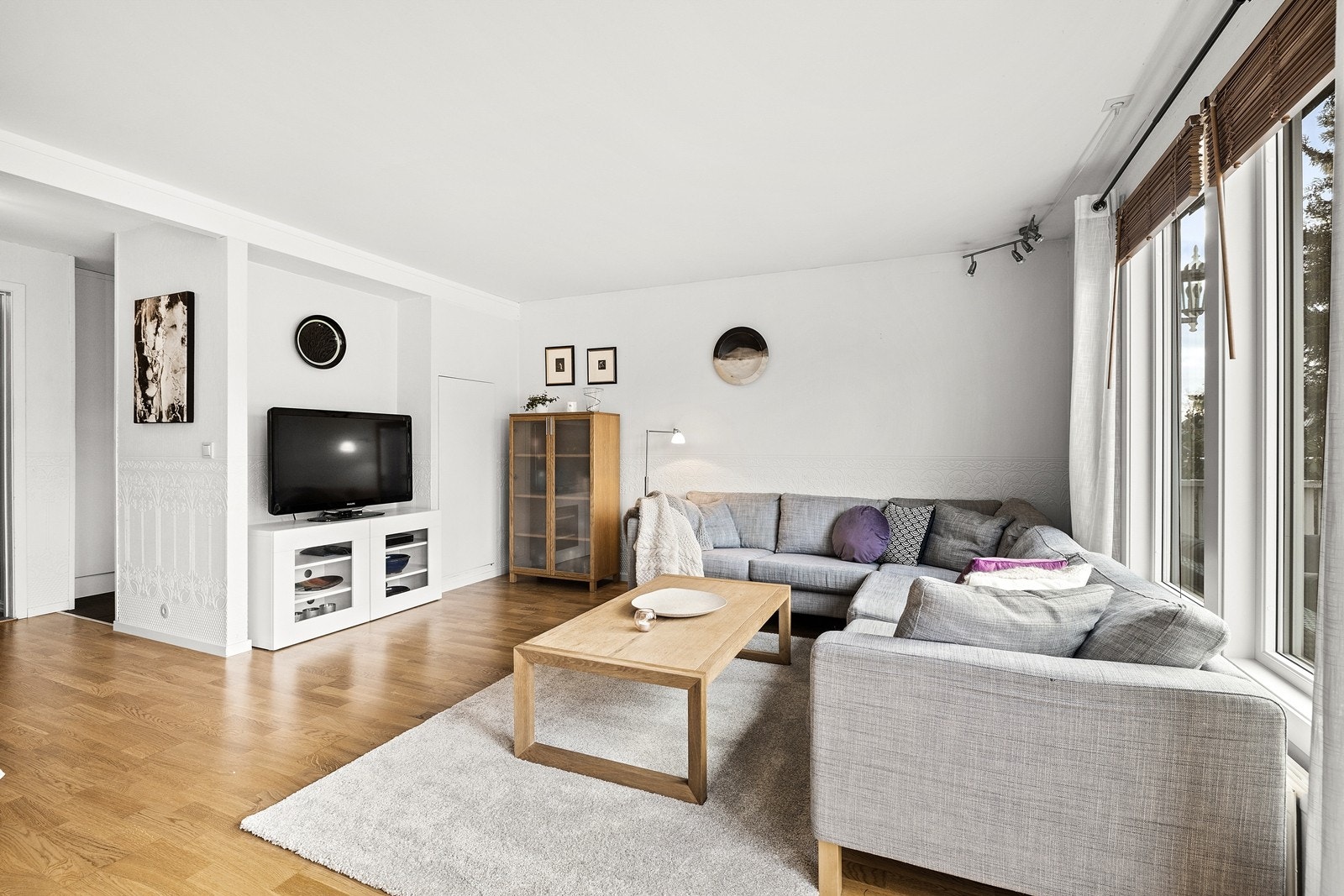 Kombinert stue/spisestue med store vindusflater gir boligen mye naturlig lys Galleribilde