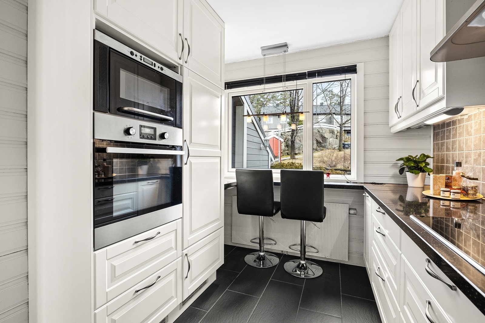 Pent kjøkken med innredning til tak som gir god skapplass. Benkeplate av granitt. Praktisk barløsning - som er en flott plass å innta frokosten Galleribilde