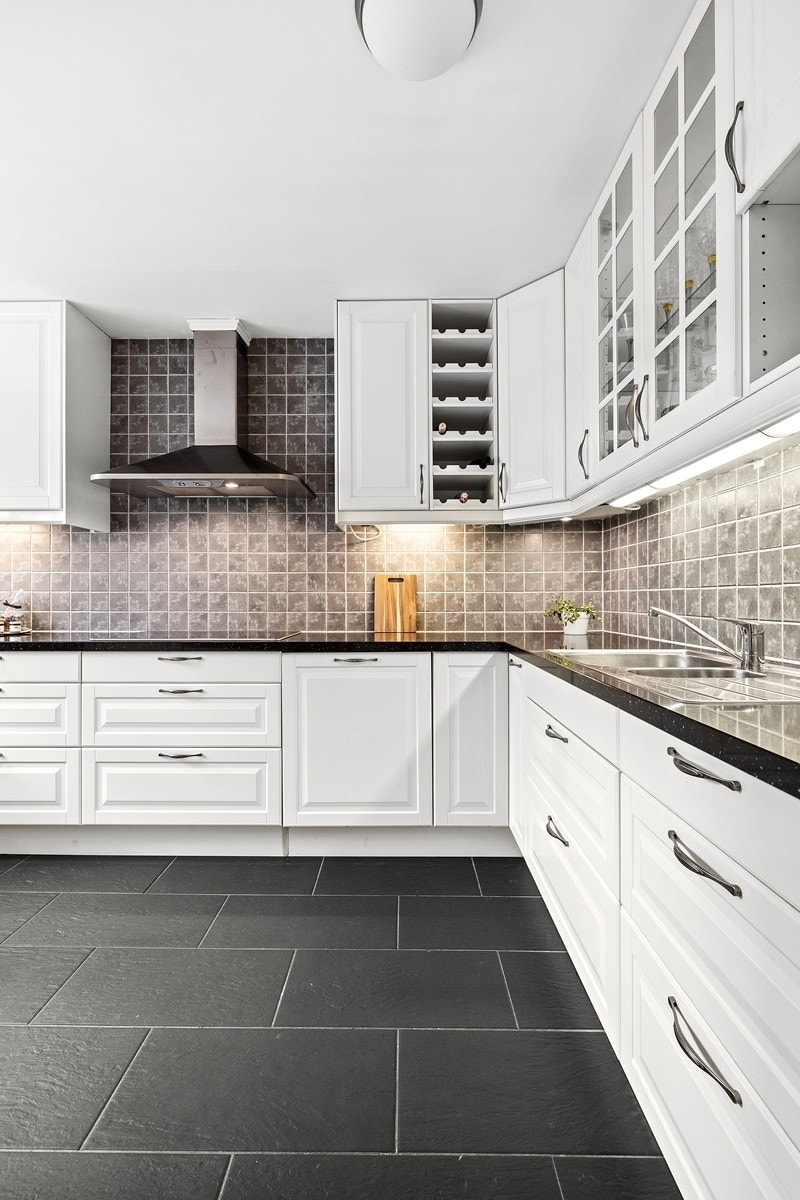 Pent kjøkken med god benk- og skapplass, integrerte hvitevarer og med praktisk barløsning Galleribilde