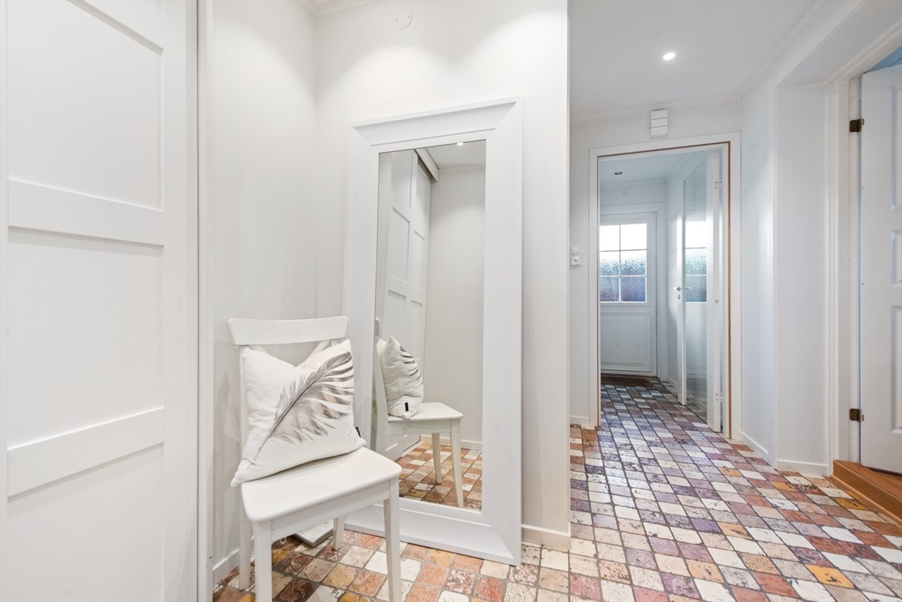 Lys og romslig entré med varmekabler og downlights i tak. Praktisk integrert skyvedørsgarderobe i entré Galleribilde
