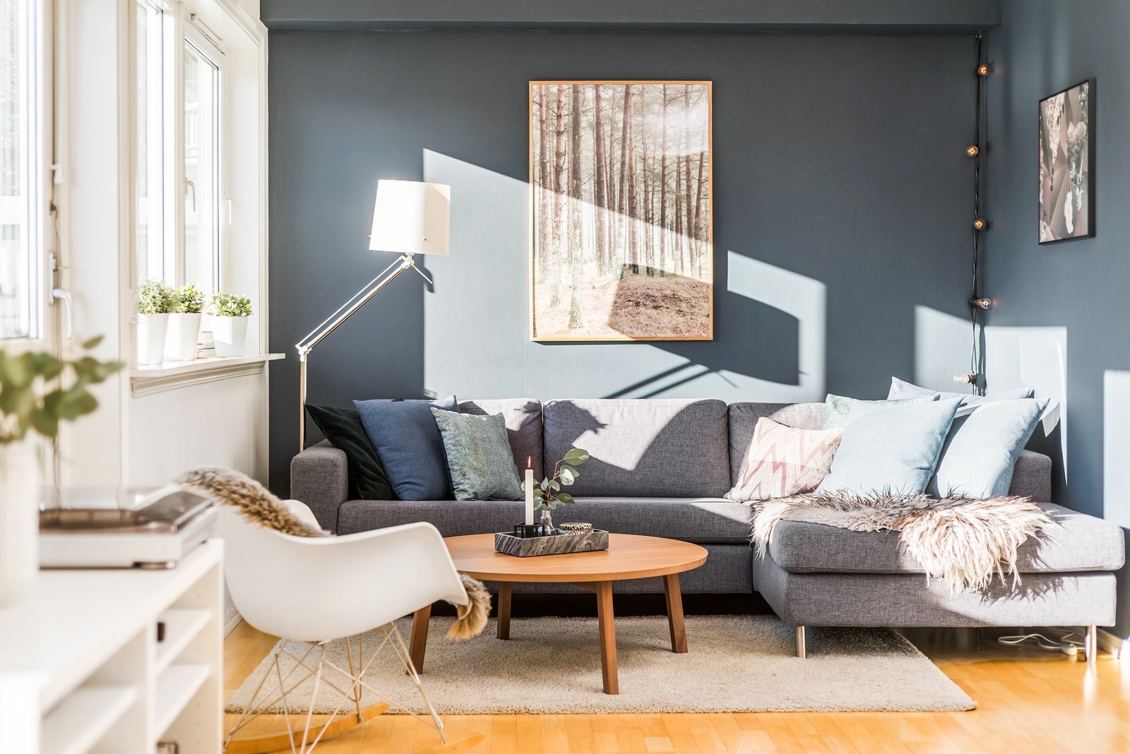 Veggene i stuen er malt i en smakfull kombinasjon av lyse og mørke, tidsriktige farger. Galleribilde