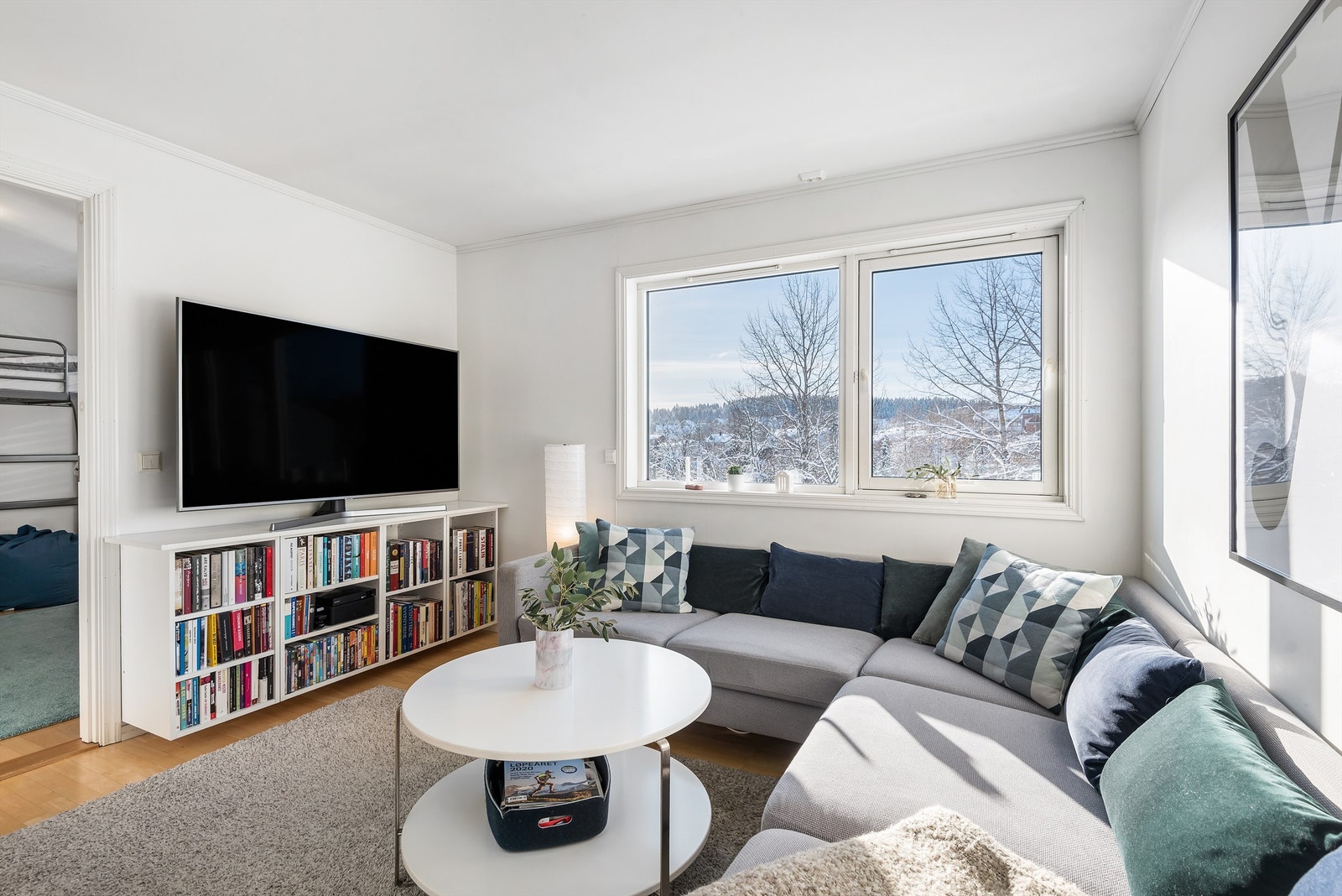 Tv-stuen har parkett på gulvet, lysmalte vegger og store vinduer. Rommet har god plass for sofagruppe, tv med mer. Galleribilde