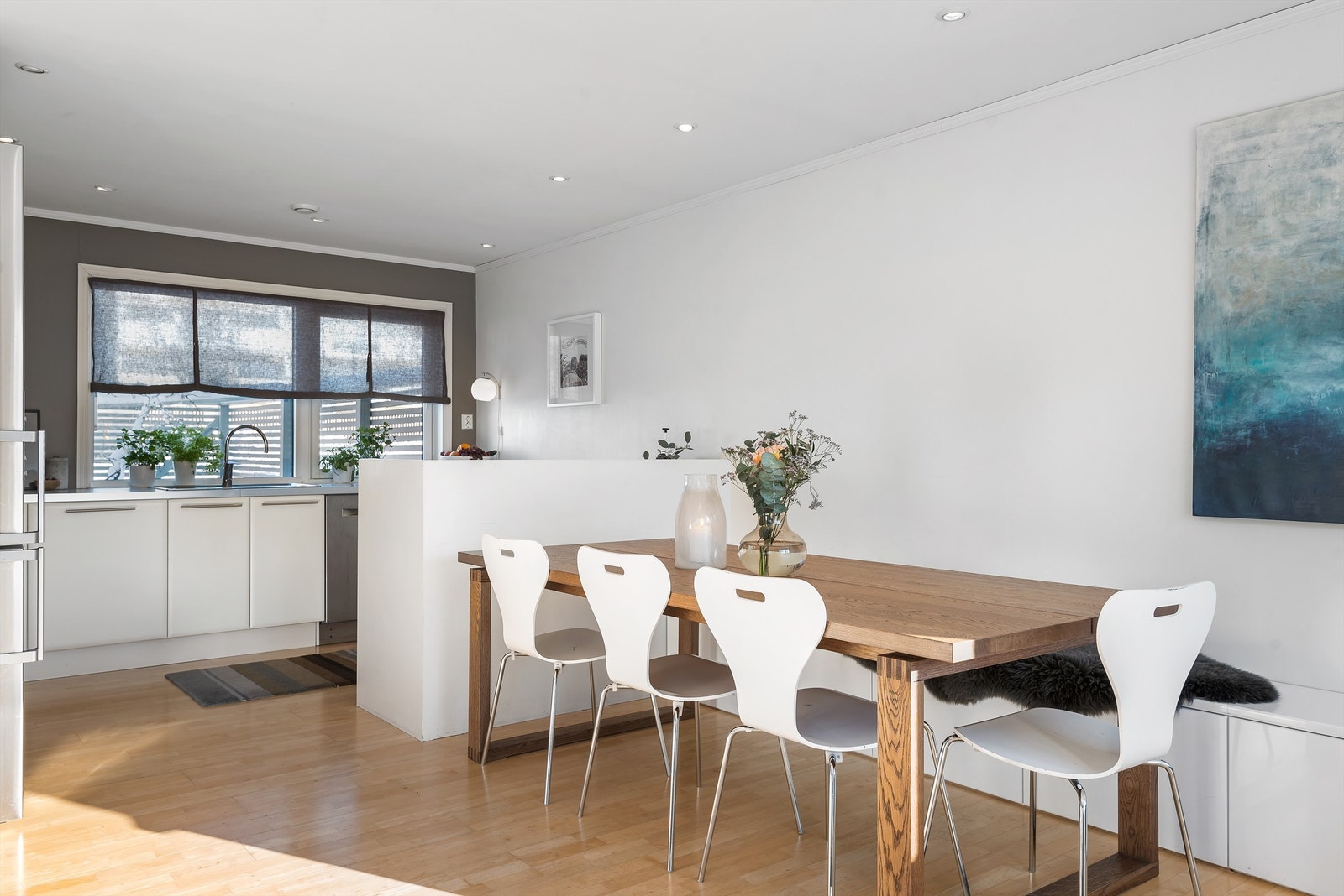 Det er plass for spisebord mellom stue og kjøkken, og en stilig barløsning skaper et naturlig skille inn mot kjøkkenet. Galleribilde