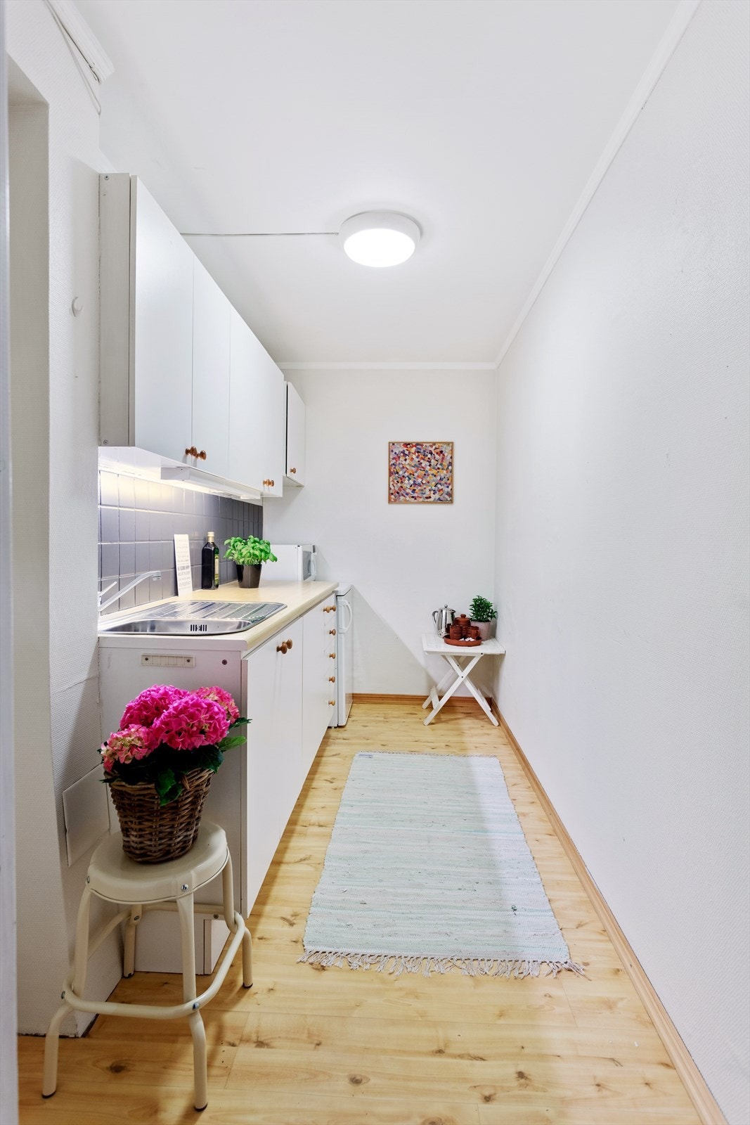 Lys kjøkkeninnredning i u.etg med glatte fronter. Opprinnelig bod, ikke søkt bruksendret. Galleribilde