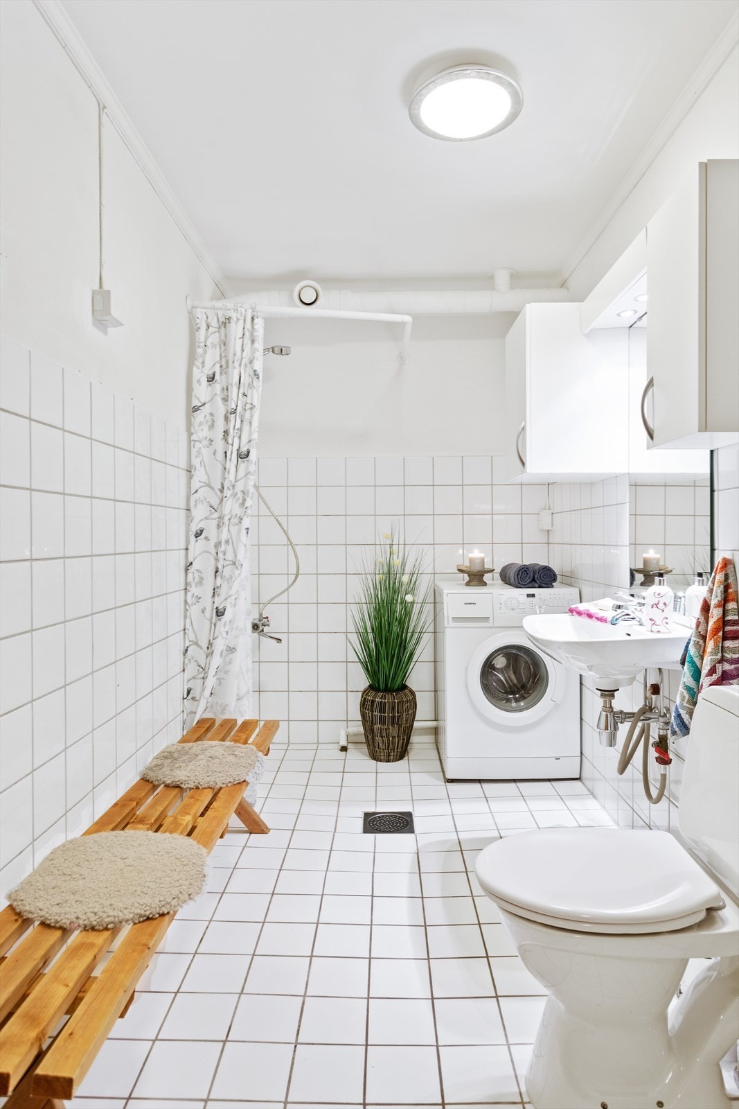 Det flislagte badet i u.etg. med varmekabler har servant, overskap med glatt utførelse, gulvstående toalett og dusjhjørne. Galleribilde