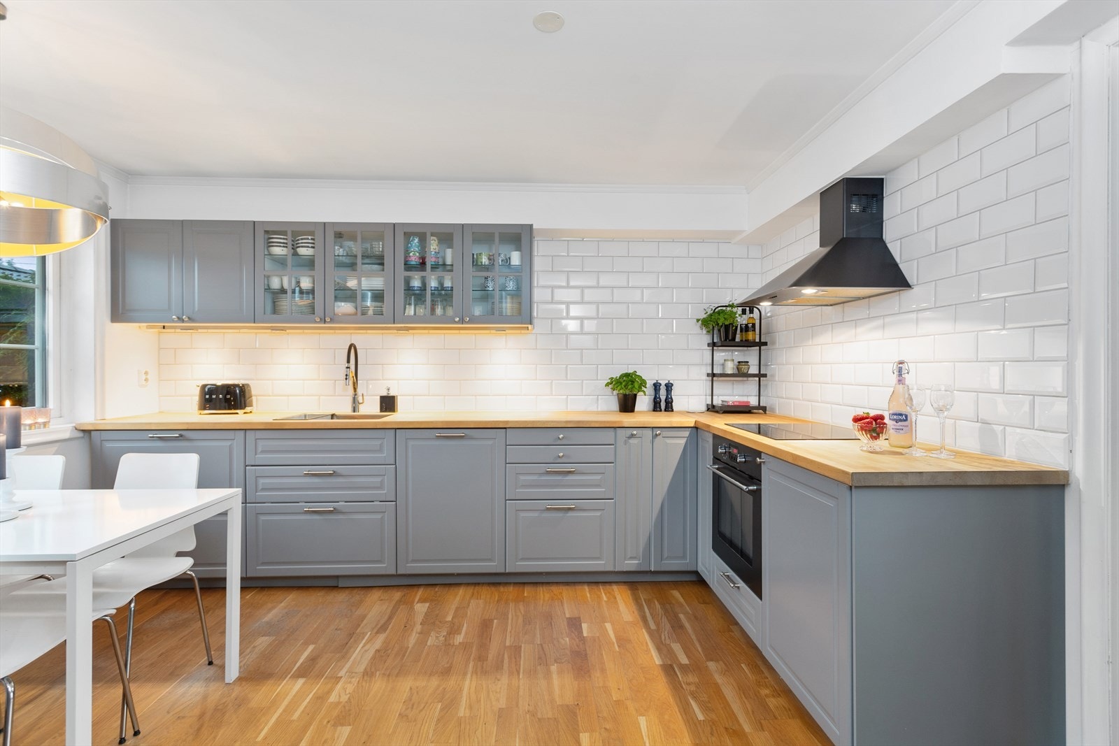 Stilrent kjøkken med fliser på veggene og parkett på gulvet. Galleribilde