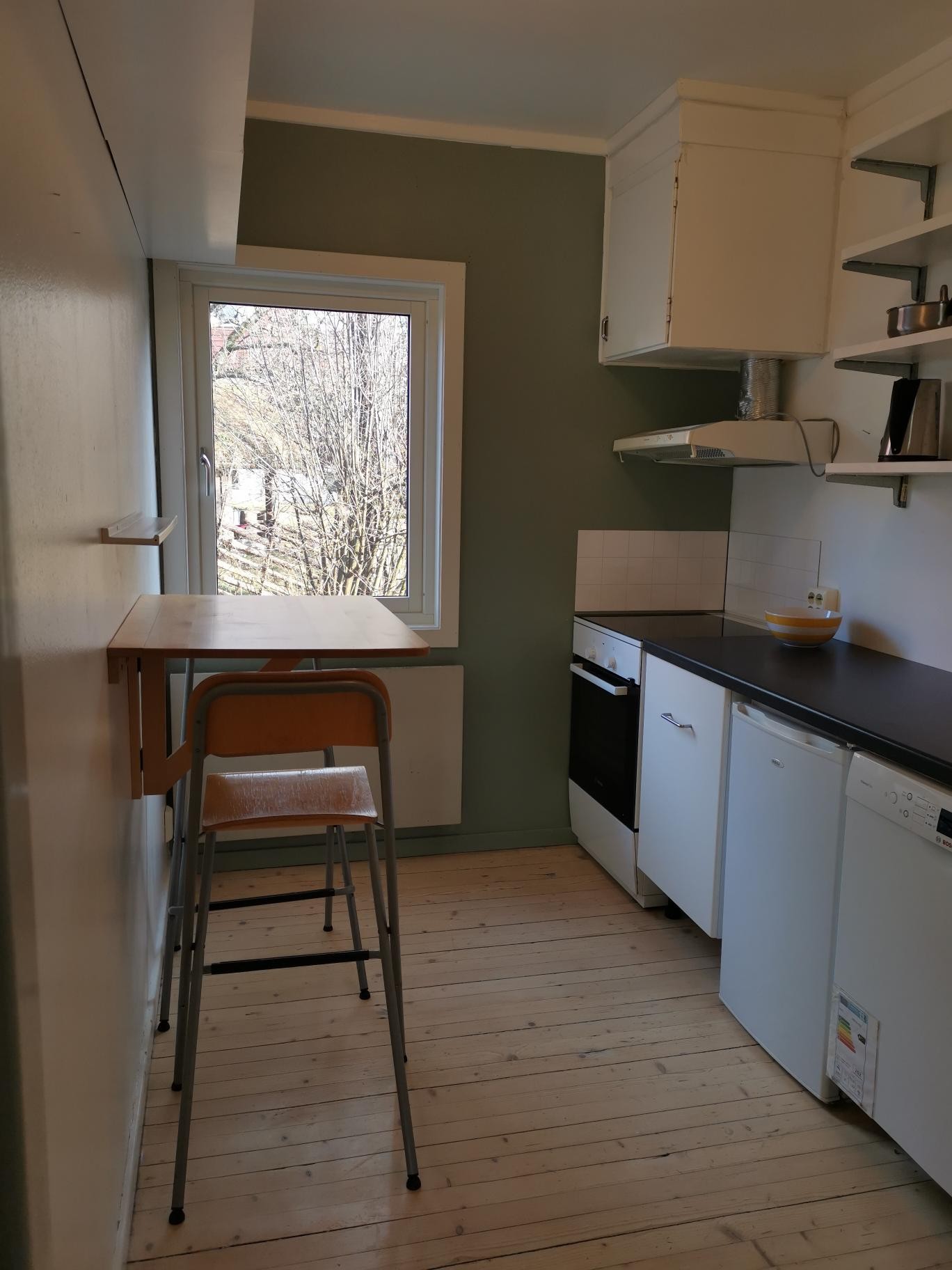 Kjøkkenet har spiseplass, komfyr og oppvaskmaskin Galleribilde