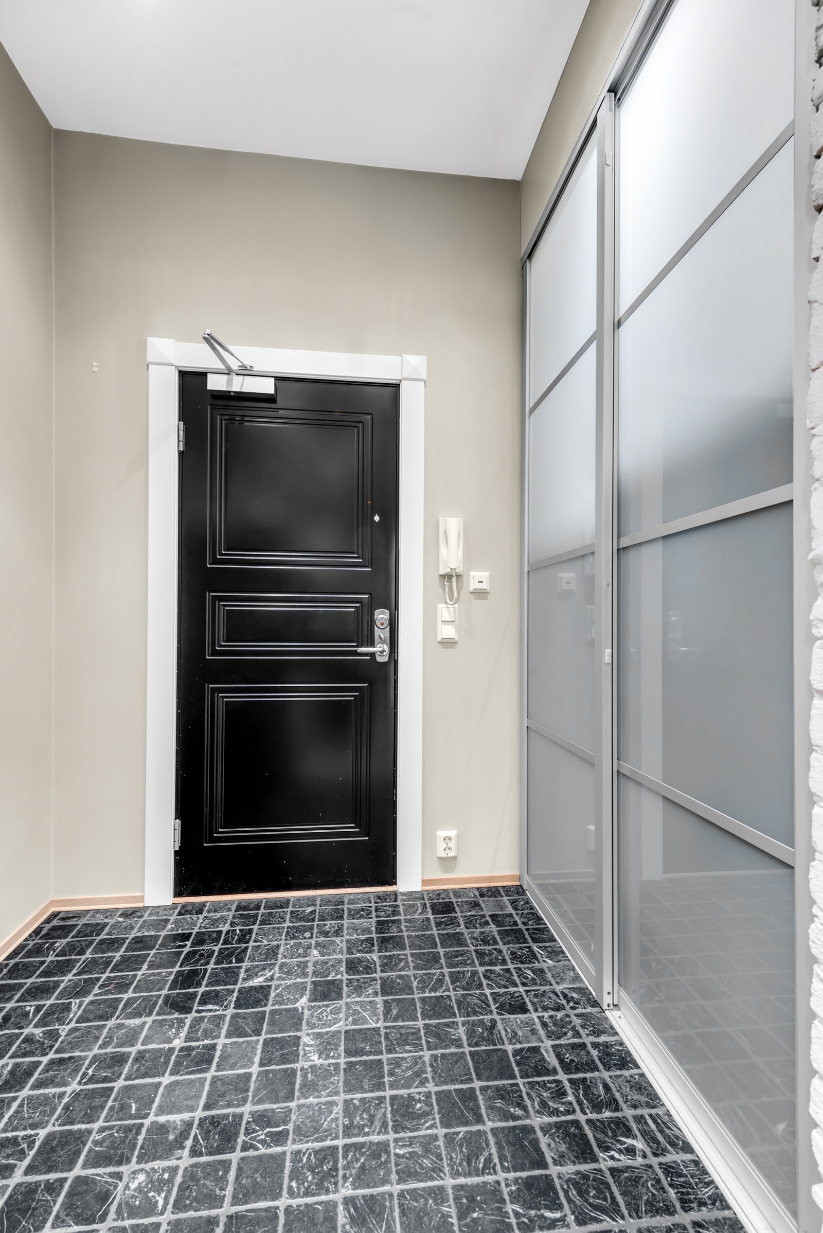 Fin flislagt inngang med varmekabler og garderobeskap Galleribilde