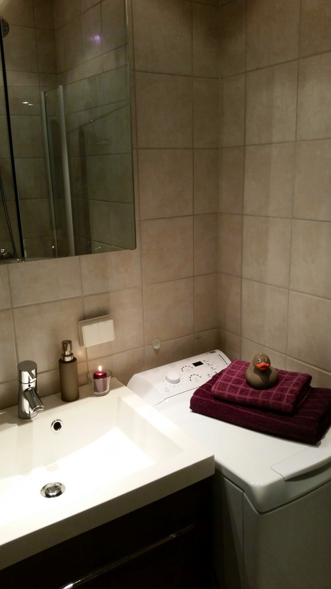 Moderne, flislagt bad med vaskeservant, skap, speil. Vaskemaskin med toppinnlegg. Ny i 2020. Galleribilde