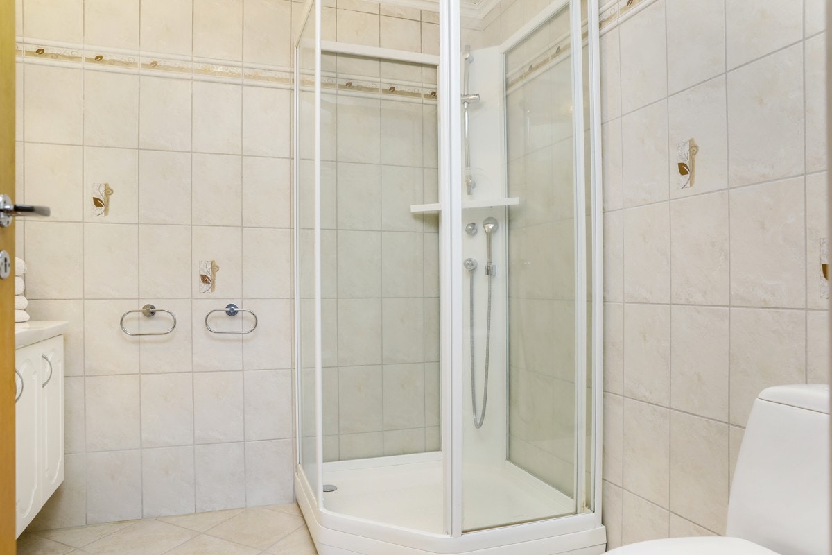 Flislagt bad med godt dusjkabinett og wc Galleribilde