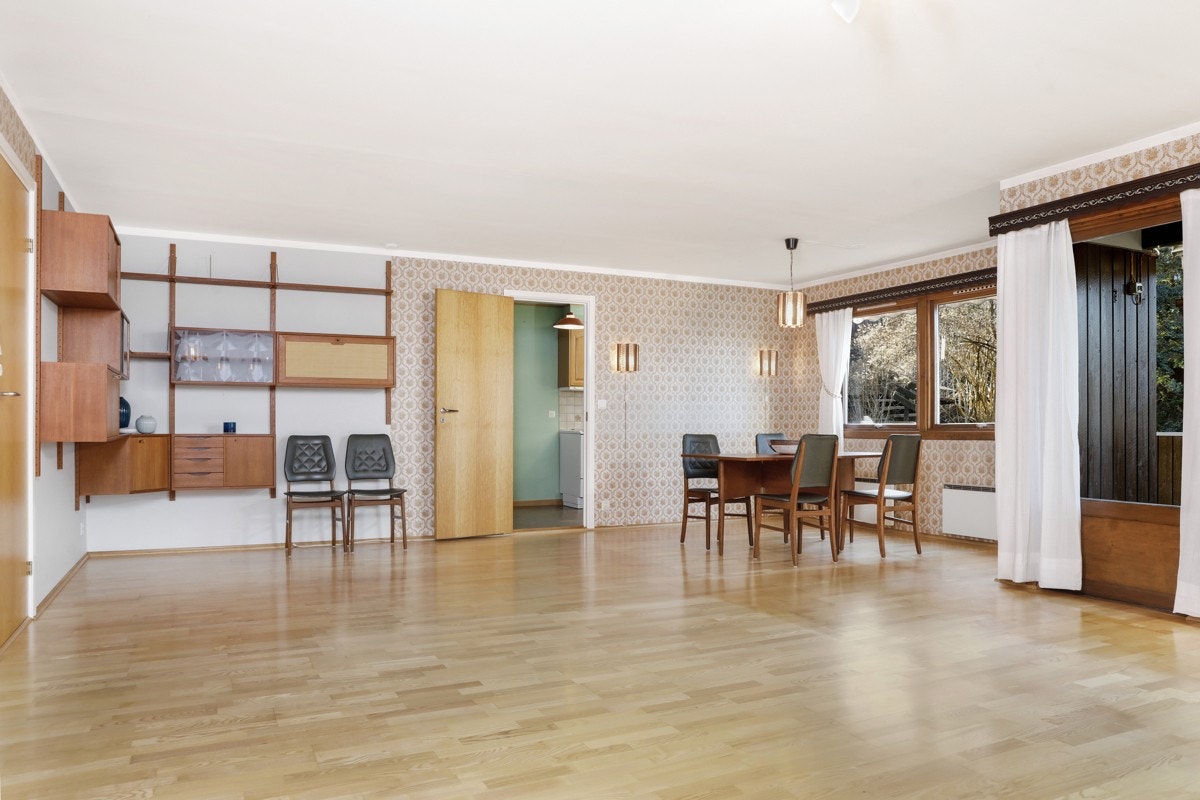 Stuen har eikeparkett på gulv. I bakgrunnen ser vi adkomst til kjøkken. Det er kun en lettvegg i mellom spissestue og kjøkken Galleribilde