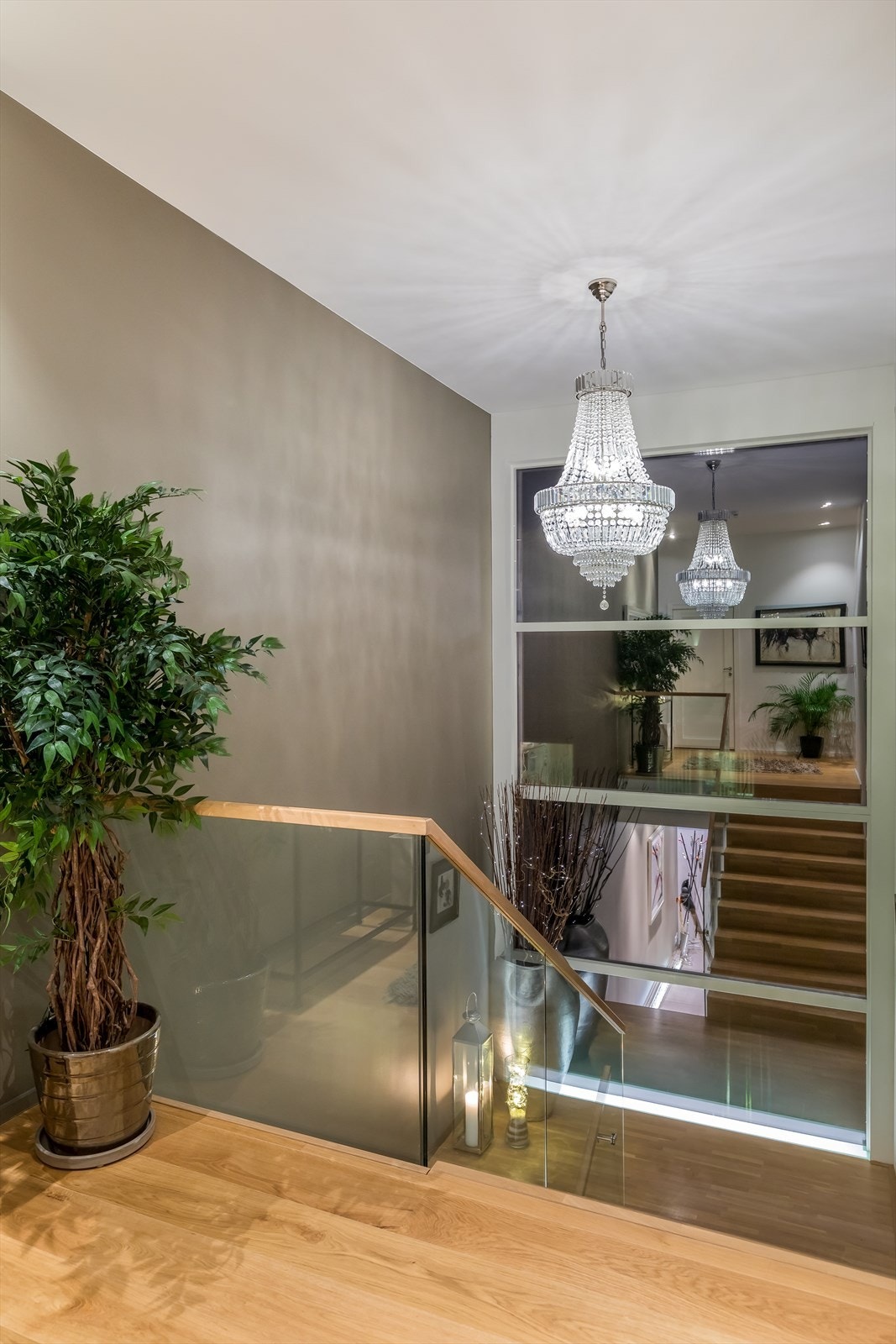 ~ Trapp med takhøye vindusflater og glassrekkverk gir et eksklusivt preg på boligen ~ Galleribilde