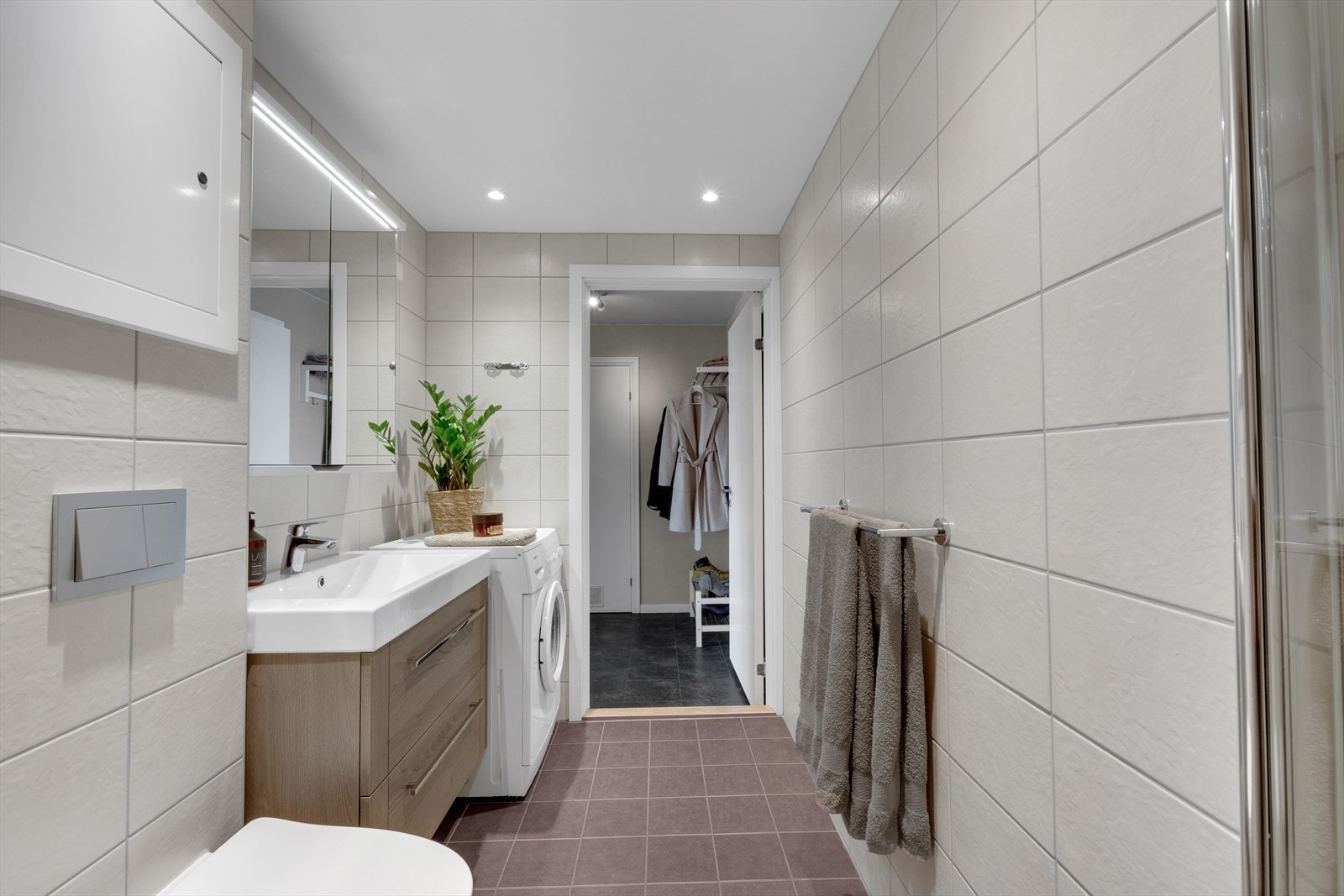 Baderommet har downlights i himling og varmerkabler i gulv, og det er opplegg for både vaskemaskin og tørketrommel. Galleribilde