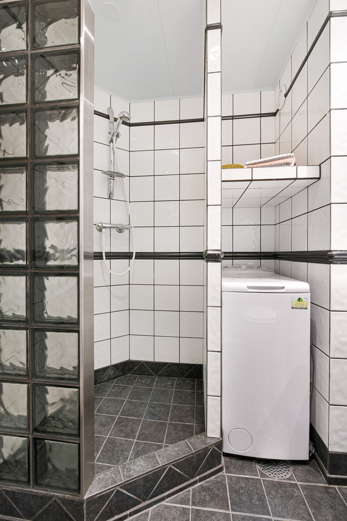 Videre har rommet gulvvarme, downlights, toalett, og en romslig dusjnisje med vegg i glassbyggerstein og innfliset vannsperre. Galleribilde