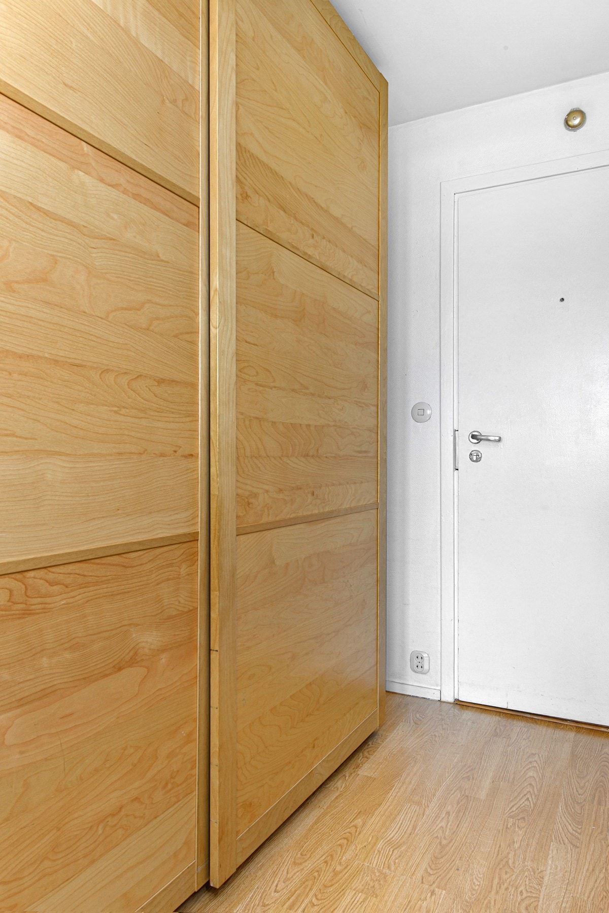 Rommet har god oppbevaringsplass i en frittstående, trehvit skyvedørsgarderobe. Galleribilde