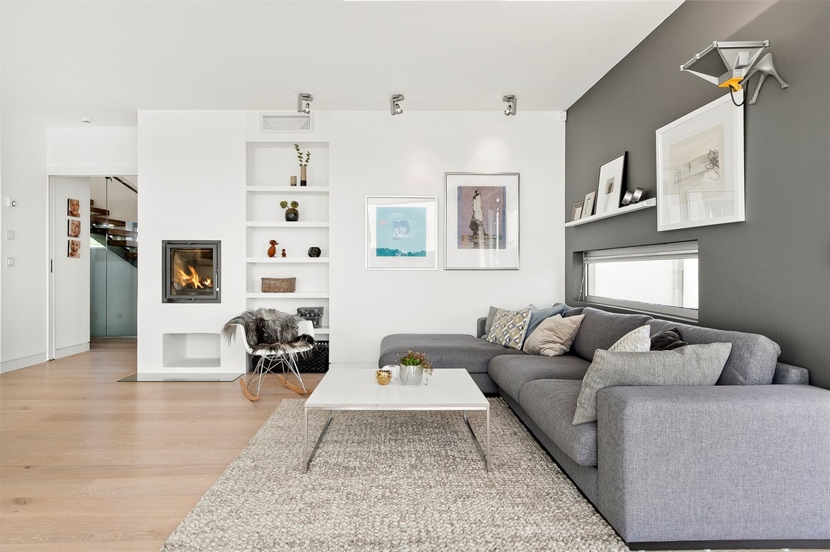 Romslig stue med fin vedovn, moderne parkett og utgang til solrik og lun terrasse. Galleribilde