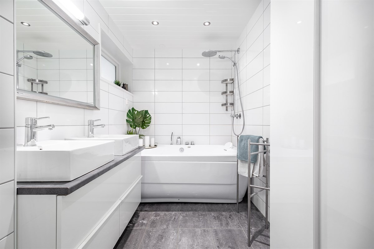 Flislagt bad med badekar og 2 servanter. Downlights i tak.