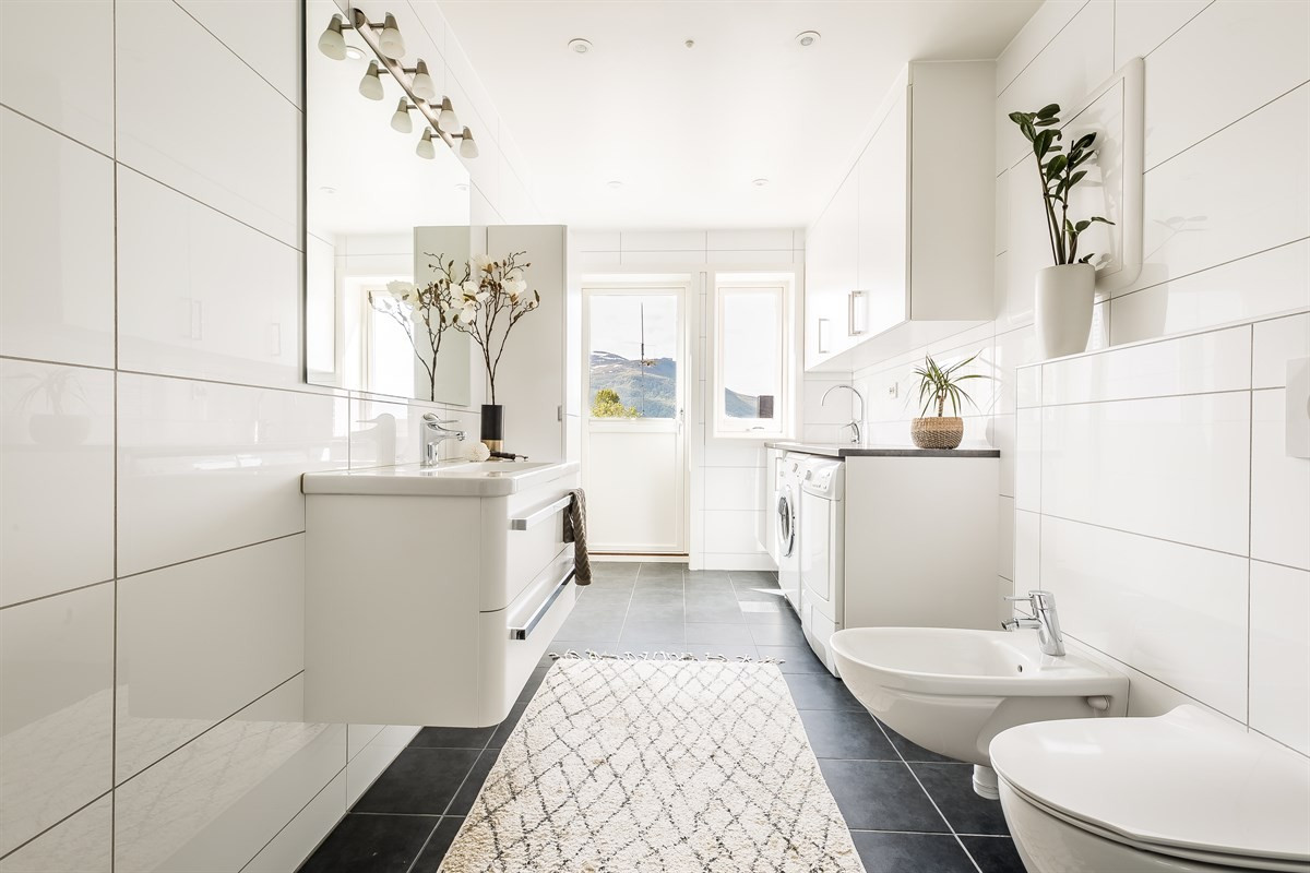 Stort flislagt bad med moderne innredning
