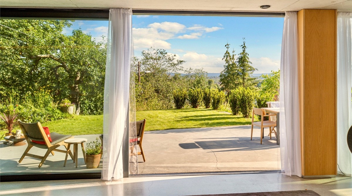 Terrassen ligger helt i flukt med stuegulvet, noe som gir en sjelden opplevelse av flyt. Ikke minst er det langstrakt utsikt og maks tilgang av lys gjennom de store vinduene. Galleribilde