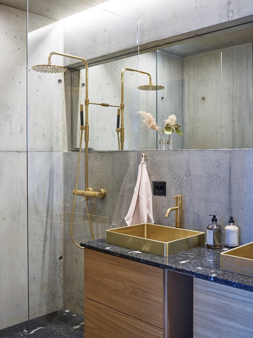 Badene har tilnærmet lik utførelse, de har hver sitt dusjhjørne med regnfallsdusj og hånddusj, det hele avgrenset med vegg i herdet klart glass. I dusjsoner er det gulv av granittplate med underliggende sluk. Galleribilde