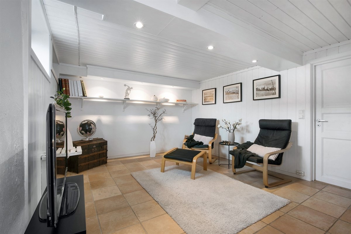 Taket har synlige dragere med downlights, og det er dagslys fra vindu. Galleribilde