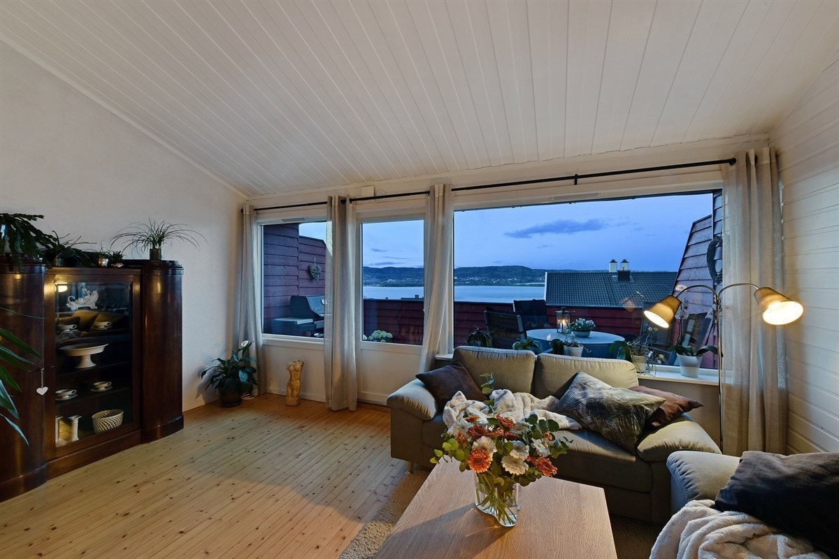 Stuen har vedovn som varmer effektivt opp, spiseplass ved kjøkkenet og god plass til sofa med tilhørende møblement. Galleribilde