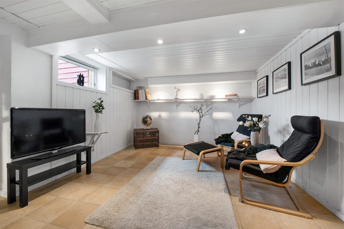 Det er gulvvarme i deler av rommet, fliser på gulv og panelte, hvite vegger. Galleribilde