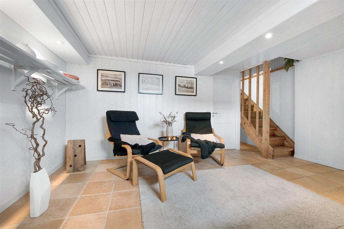 Veggen innerst har en åpen hylle til bøker og dekorasjon. Galleribilde