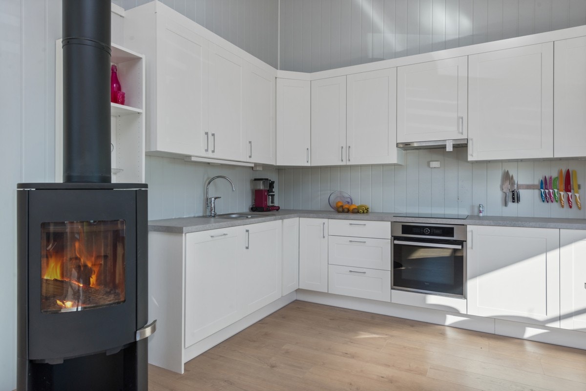 Kjøkkenet er moderne og har godt med både skap og benkeplass Galleribilde