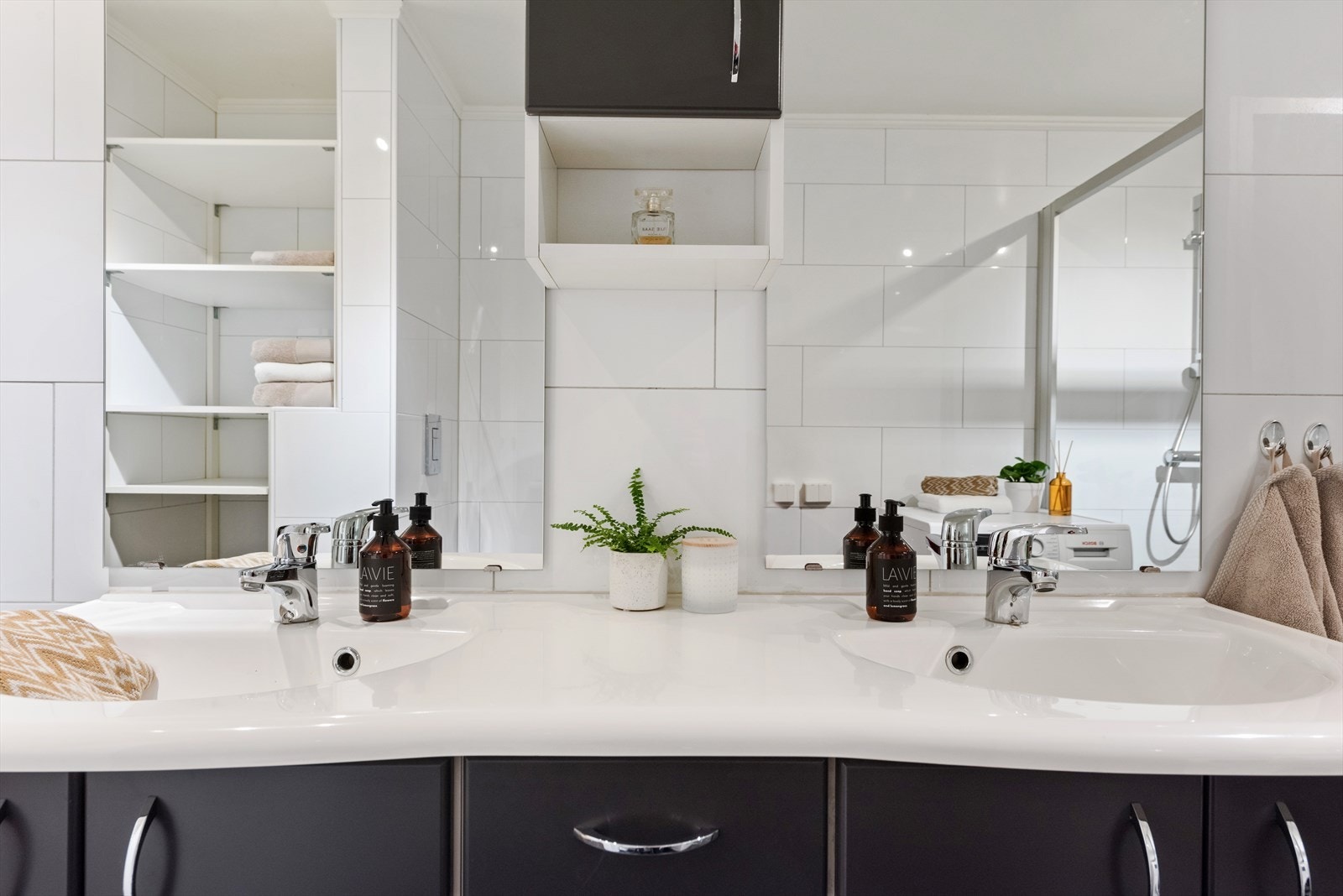 Baderomsiningen består av flere benkeskap, dobbel vask, vegghengt klosett, dusj med innfellbar dør i herdet glass og opplegg for vaskemaskin Galleribilde