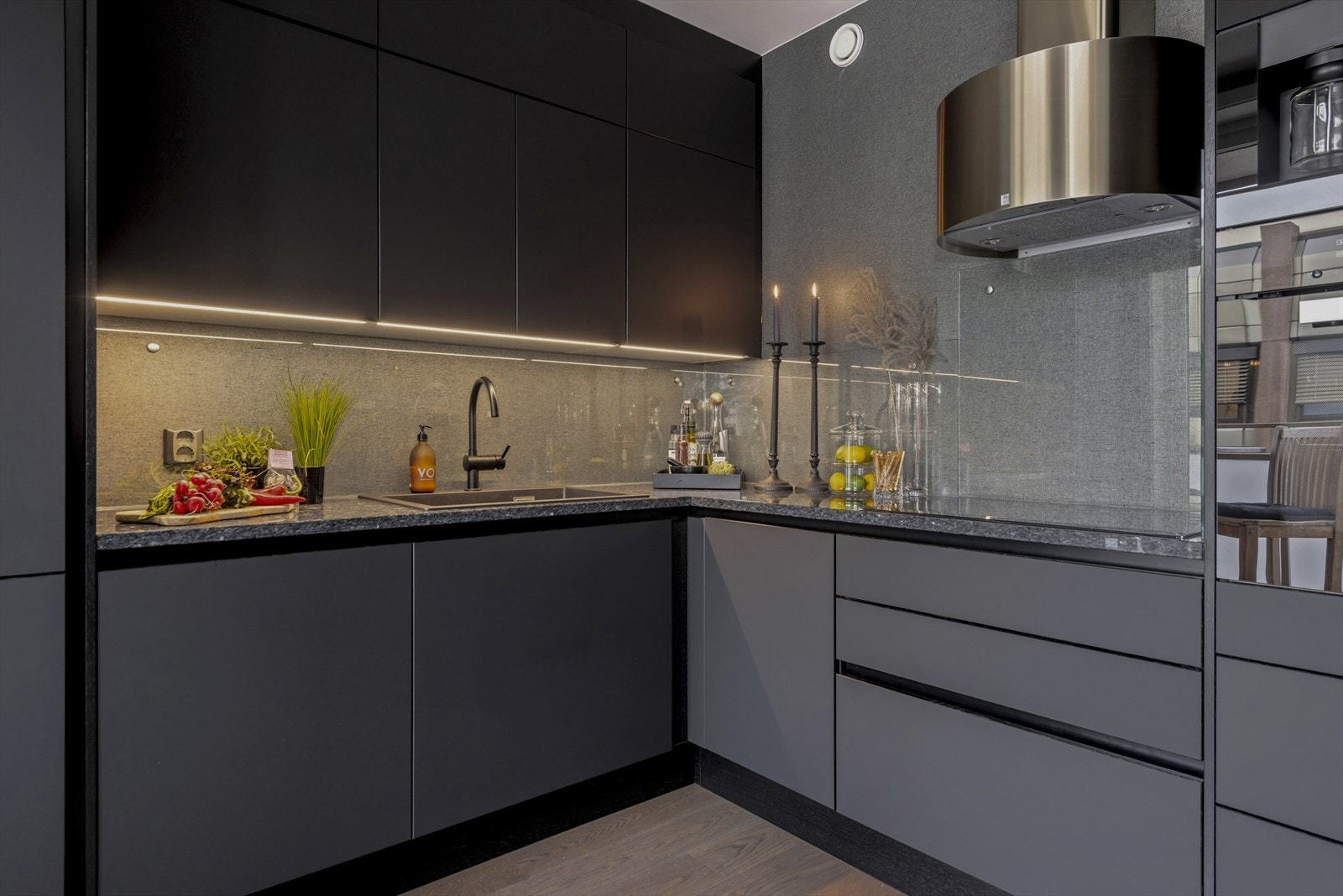 Granitt benkeplate, herdet glass i sprutsone over benk, kjøkkenvifte fra Røros hetta i messingfarge. Galleribilde