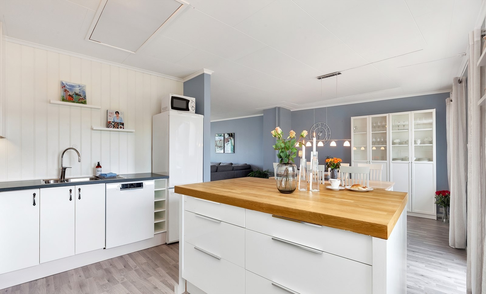 Kjøkkenet har en praktisk kjøkkenøy med skuffer på den ene siden og barløsning på den andre Galleribilde