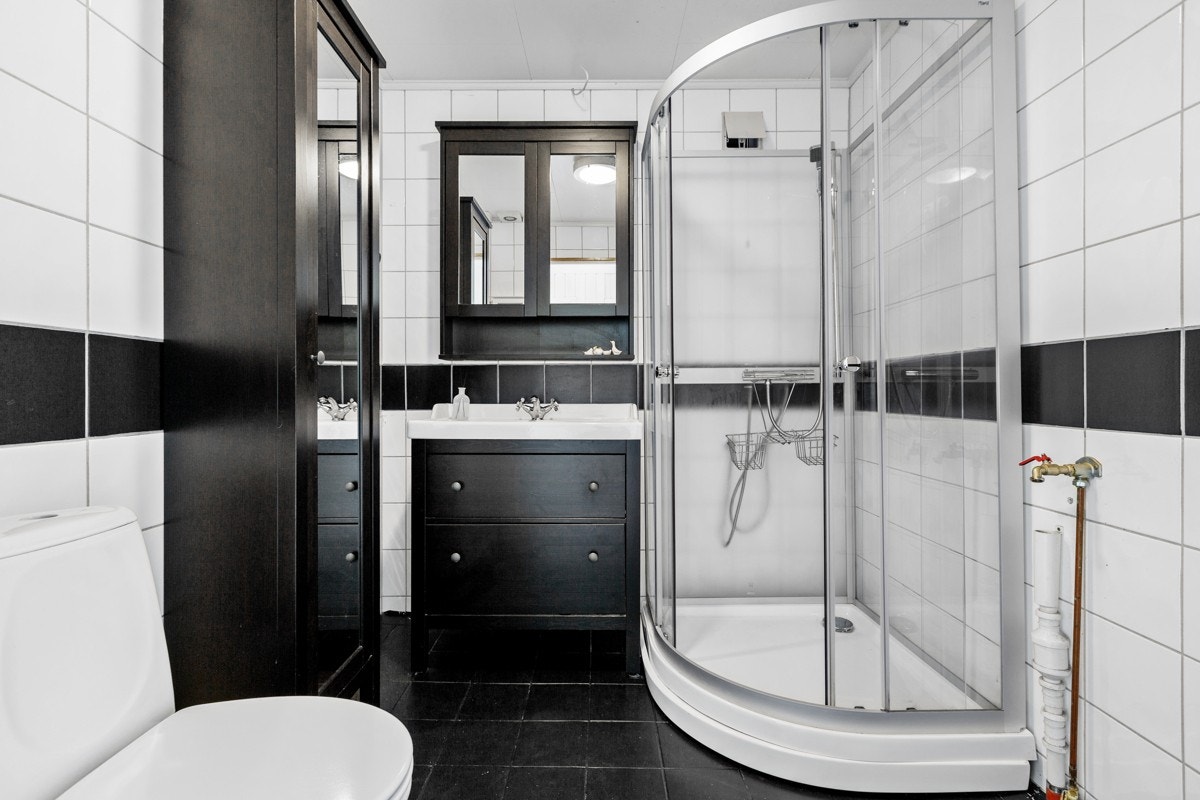 Badet er oppgradert de senere år og har heldekkende servant, sort servantmøblement, matchende høyskap og speilskap. Galleribilde