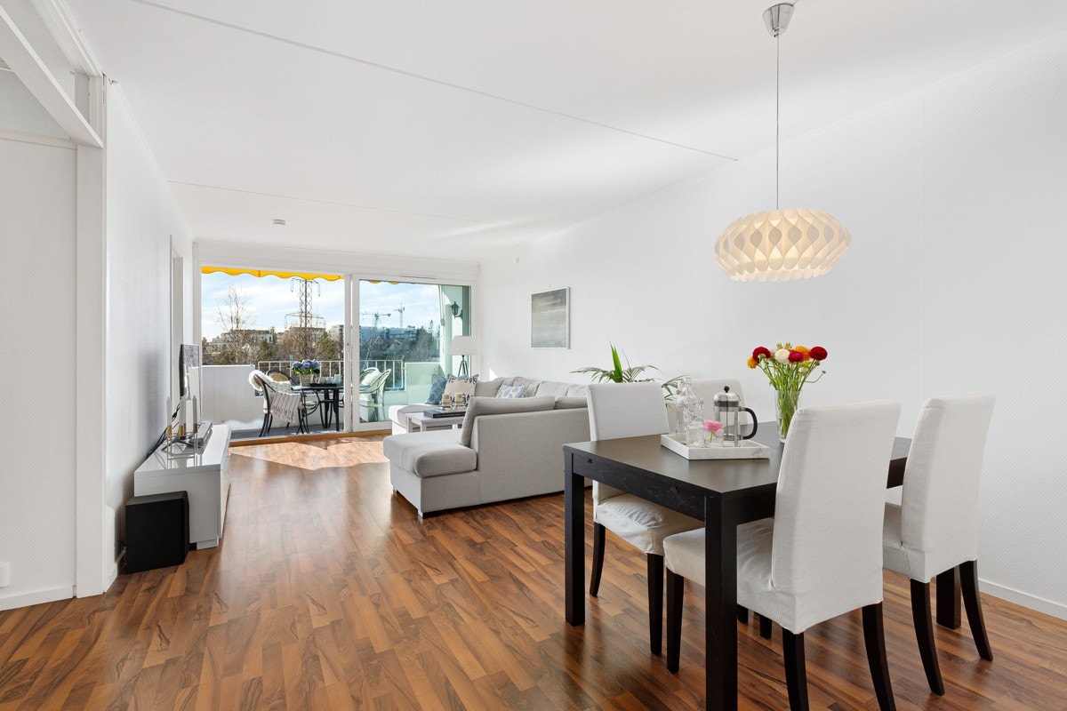 Stuen er lys og luftig med rikelig lysinnslipp fra en stor, dobbel skyvedør i glass mot balkongen. Galleribilde