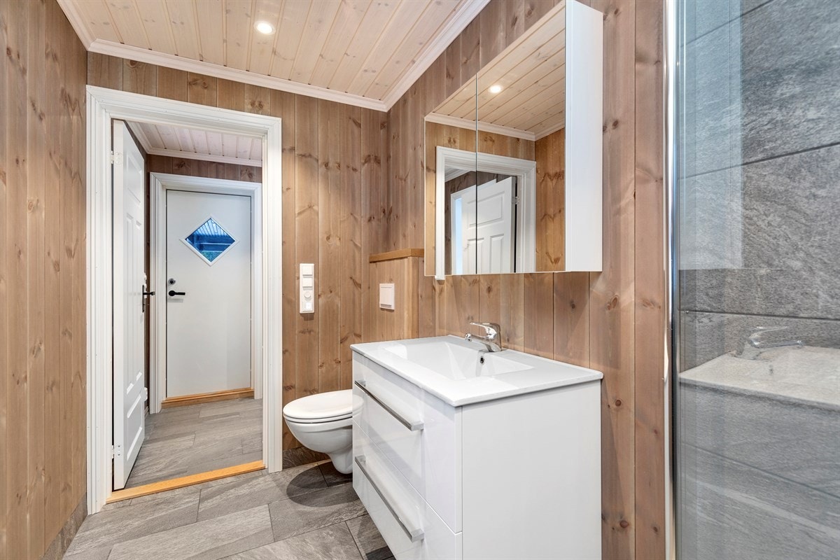 Bad med fliser på gulv og i dusjhjørne. Galleribilde