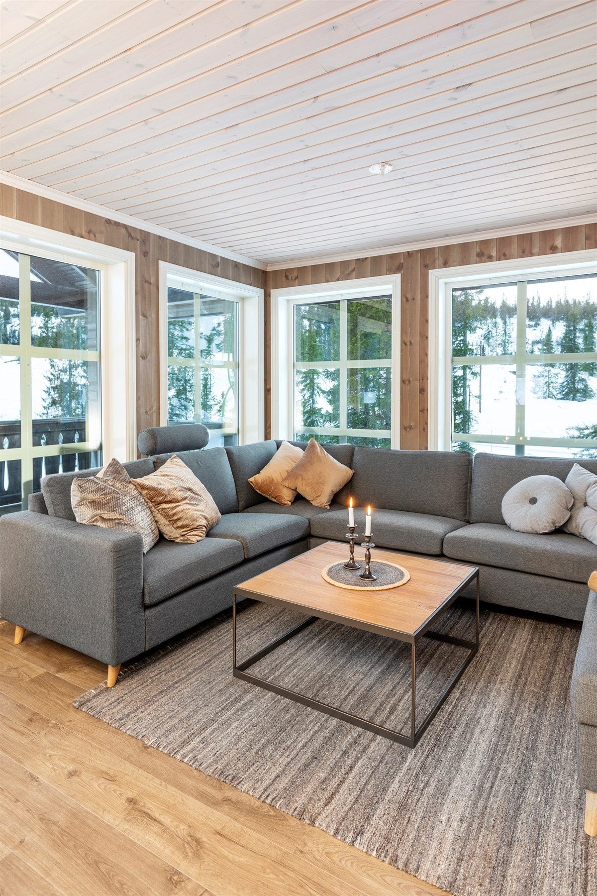 Romslig stue med store vindusflate som slipper naturen inn i stua. Galleribilde