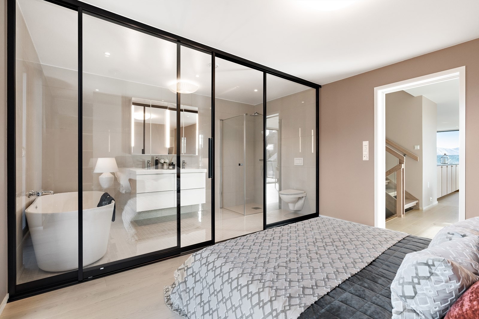 Badet tilhørende hoved soverommet er moderne og har store vindusflater med skyvedør Galleribilde