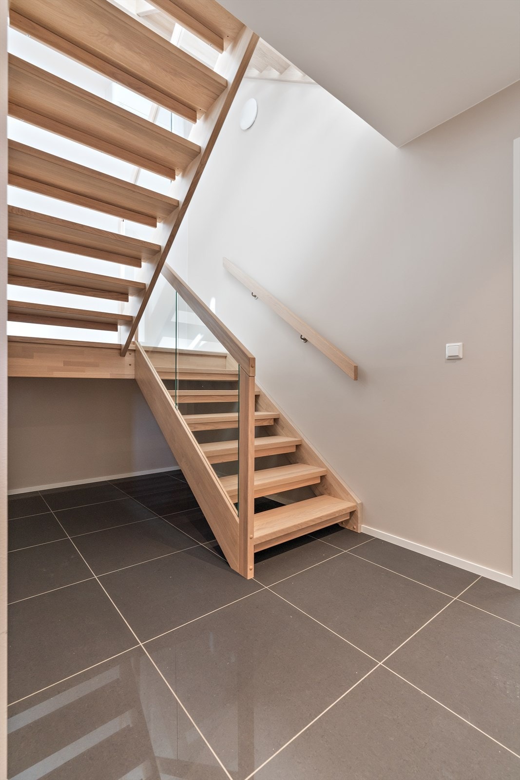 Flott eiketrapp med glass som er gjennomgående i boligen Galleribilde