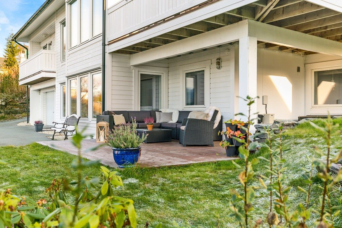 På sommeren er det en lun terrasseplatt med plass til sofagruppe
